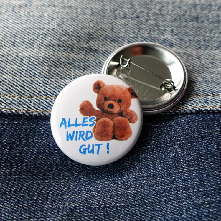 Ansteckbutton Alles wir gut! auf Jeans mit Rückseite